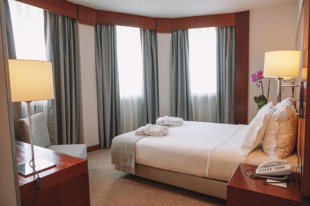 מיטה או מיטות בחדר ב-Hotel Dom Carlos Liberty