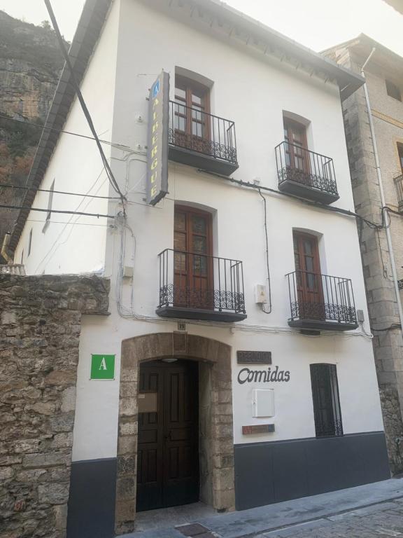 un edificio blanco con balcones en un lateral en Albergue-Refugio Sargantana en Canfranc