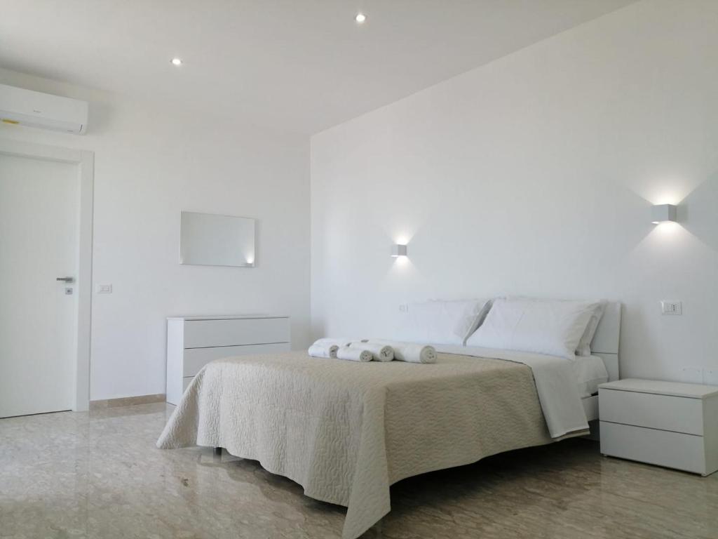 a white bedroom with a large bed with white walls at AMARE Bed & Breakfast in Rodi Garganico