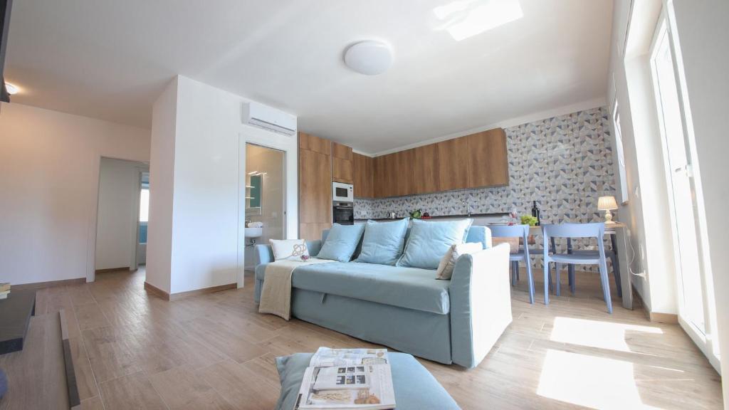 Una sala de estar con un sofá azul y una mesa. en Dimora Paradiso, Monopoli, Puglia, Sea-View, Stylish, Family Friendly Home, en Monopoli