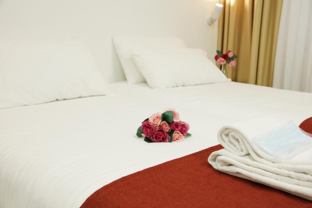 una habitación de hotel con un ramo de rosas en una cama en Hostal Royal Cruz, en Madrid