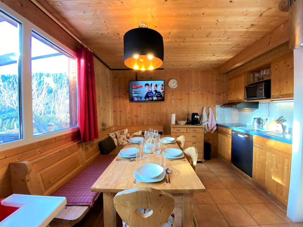 ein Esszimmer mit einem Tisch und einer Küche in der Unterkunft EXCLUSIVES Chalet an der SKIPISTE +Dampfbad +NETFLIX in Hohentauern