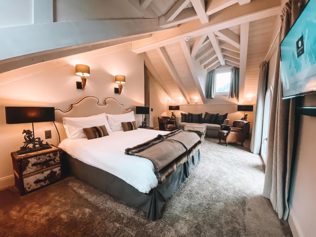 a bedroom with a large bed and a tv at Hôtel Le White - Le 42 Restaurant in Champéry