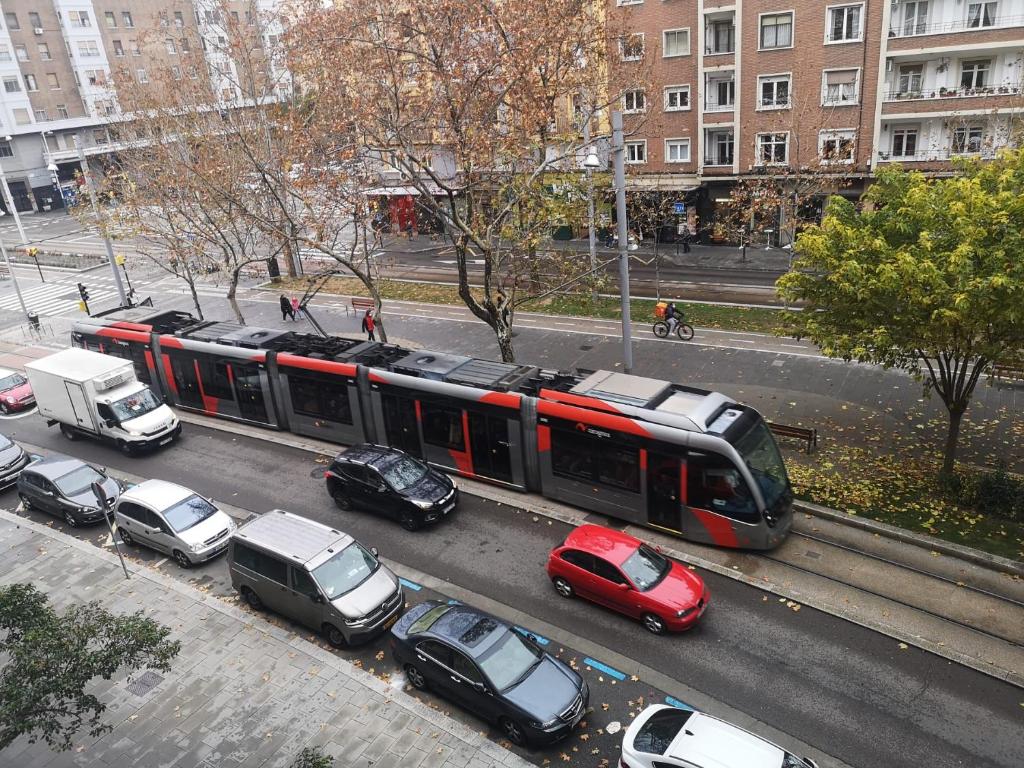 um comboio numa rua da cidade com carros estacionados em LC Gran Vía em Saragoça