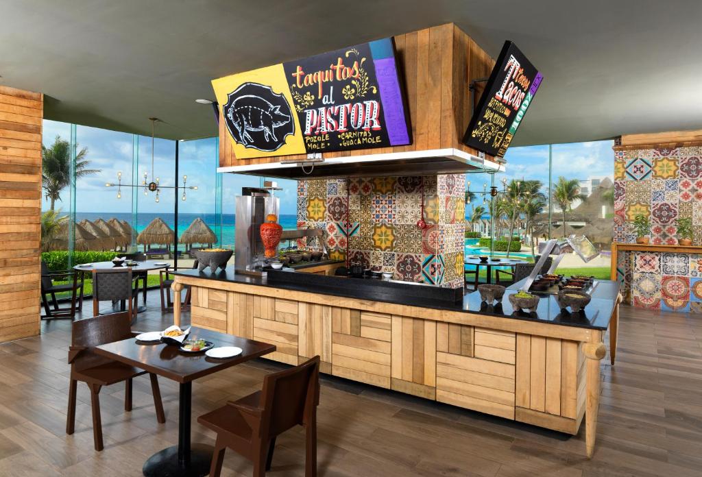 a restaurant with a bar with tables and chairs at Paradisus Cancun All Inclusive in Cancún