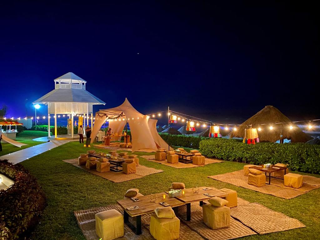 a tent with couches and tables in a field at night at Paradisus Cancun All Inclusive in Cancún