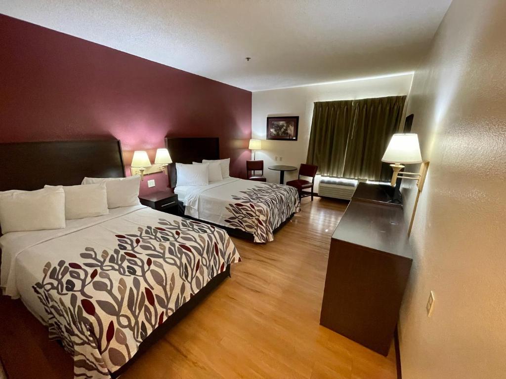 a hotel room with two beds and a desk at Red Roof Inn Clyde in Clyde