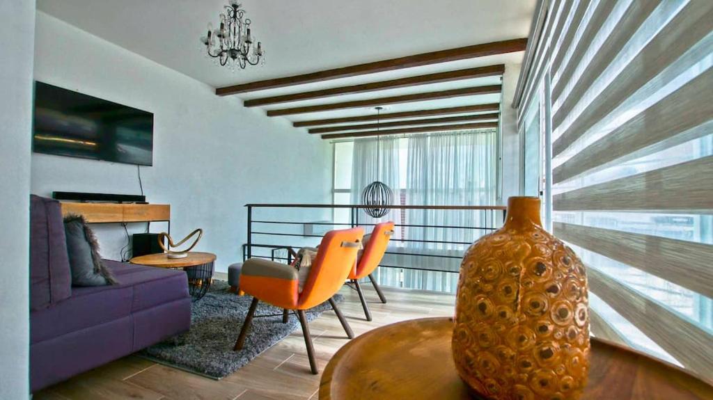 a living room with a purple couch and a vase on a table at Nice Apartment in Santiago, Near Popular Places in Santiago de los Caballeros