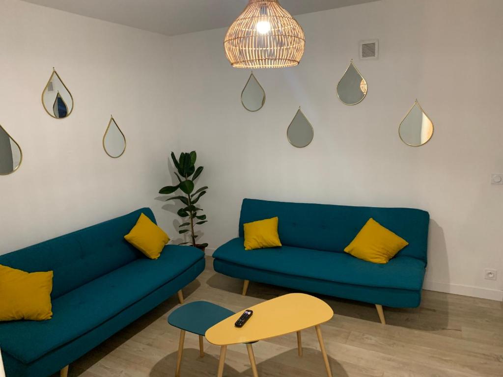 a living room with two blue couches and a table at L EFFET MER 70M2 avec 2 chambres doubles avec Parking 1 voiture GRATUIT, Netflix Disney plus disponible Lits faits à l arrivé Serviettes de toilettes fournies in Dieppe