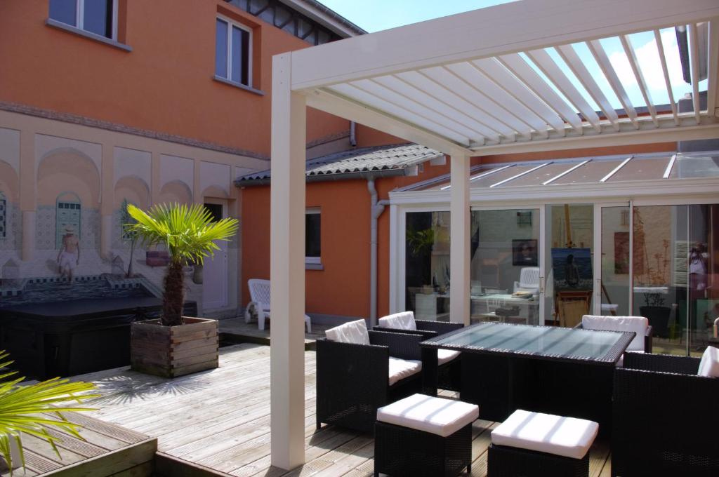 pérgola en un patio con mesa y sillas en La Maison de L Artiste - Chambres d'hôtes à Verdun - avec jacuzzi, en Verdún