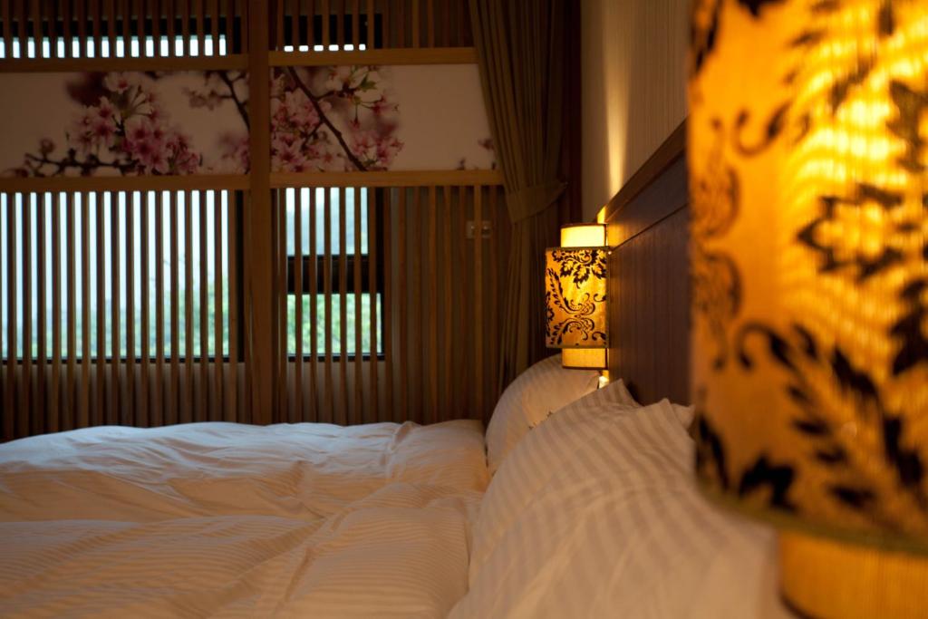 a bedroom with a large bed and a lamp at Li Wu Zuo Cun B&amp;B in Chongde