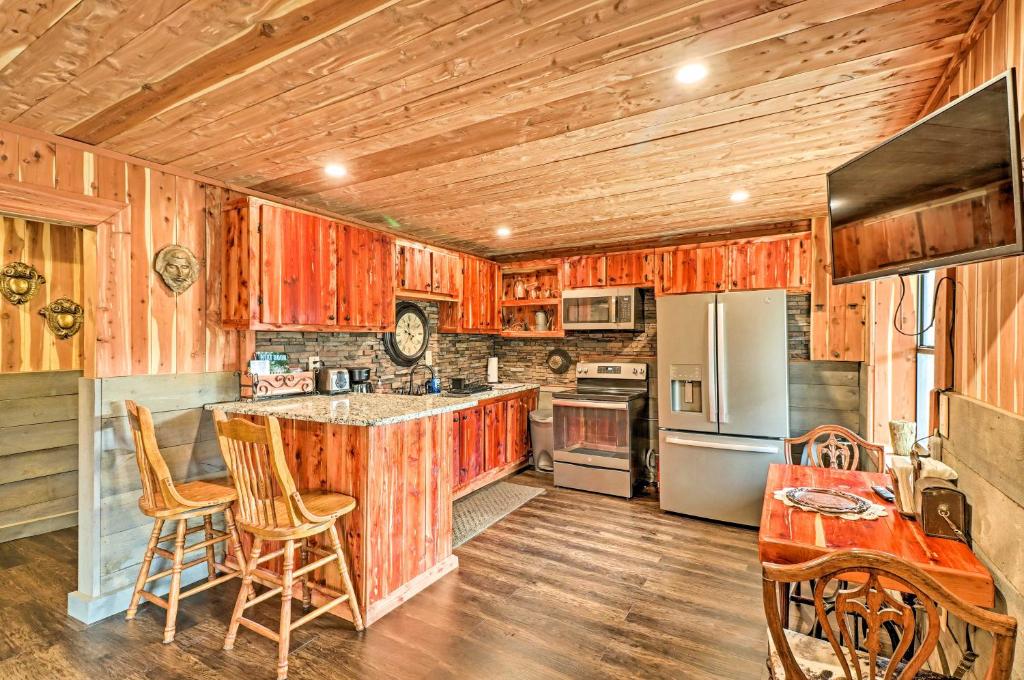 a kitchen with wooden cabinets and a counter top at Quiet, Historic Manor Located in Ghost Town! in Calico Rock
