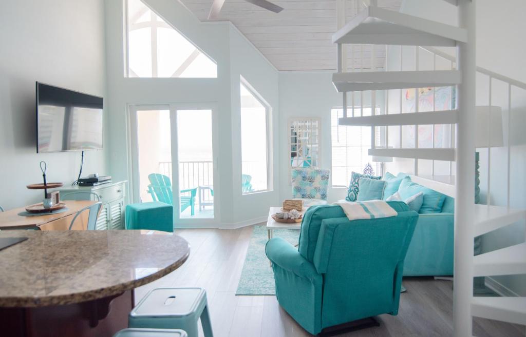 a living room with a blue couch and a table at Grand Beach Resort Penthouse 1 in Gulf Shores