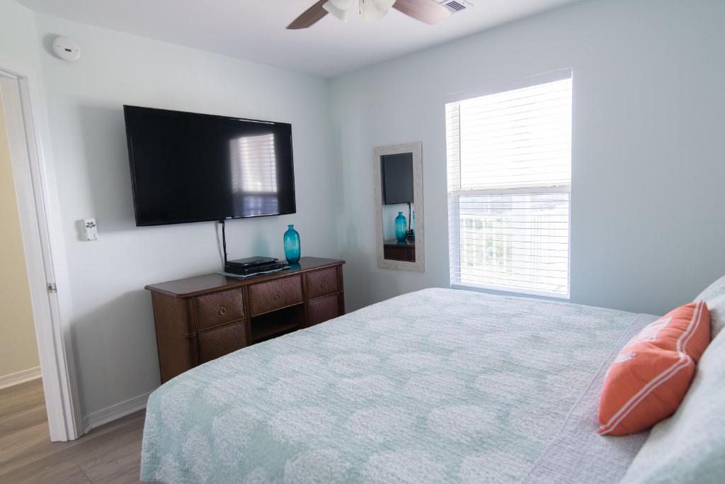 ein Schlafzimmer mit einem Bett und einem Flachbildfernseher in der Unterkunft Grand Beach Resort Penthouse 1 in Gulf Shores
