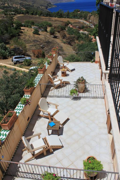 an outdoor patio with chairs and chairs on a balcony at Torre Bennistra in Scopello