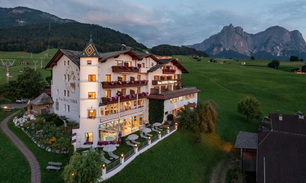 une vue aérienne sur un hôtel avec des montagnes en arrière-plan dans l'établissement Parc Hotel Tyrol, à Castelrotto