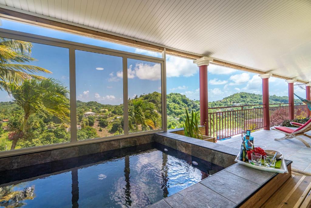 a swimming pool with a view of the mountains from a house at Vert Ocean in Le Marin
