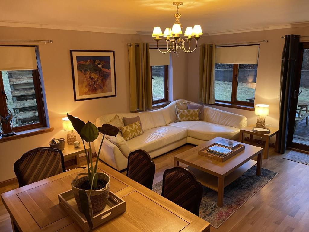 a living room with a couch and a table at Foxglove Cottages in Drymen