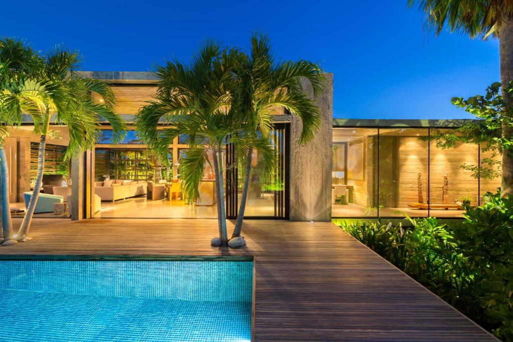 a house with a swimming pool and palm trees at Villa Islander in Providenciales