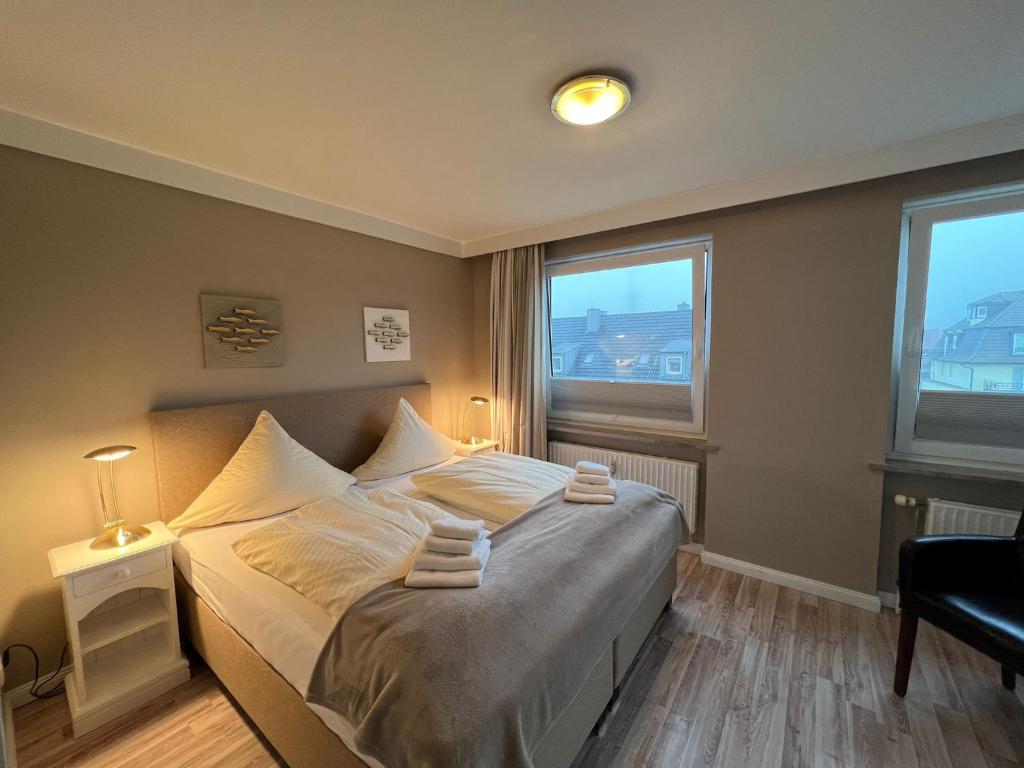 1 Schlafzimmer mit einem großen Bett und 2 Fenstern in der Unterkunft Muschelsucher in Westerland