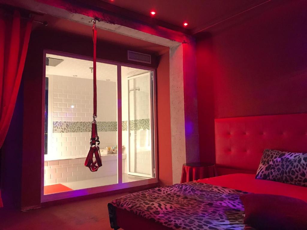 a red room with a bed and a window at La Mazmorra de Lucifer in Madrid