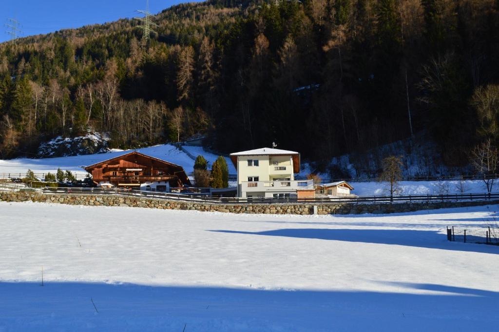 a house in the snow next to a snow covered field at Haus Raich - Pitztal Card im Sommer inklusive in Arzl im Pitztal