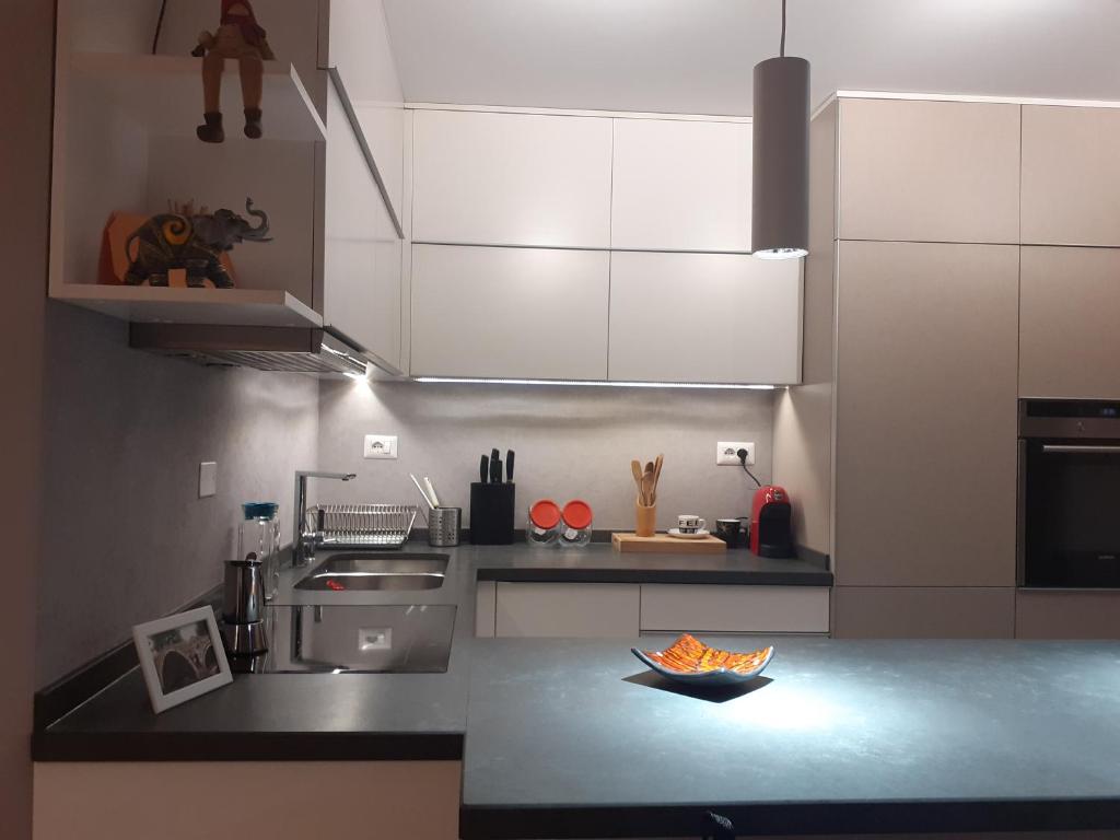 uma cozinha com armários brancos e uma bancada em Lake View Apartment em Tirana