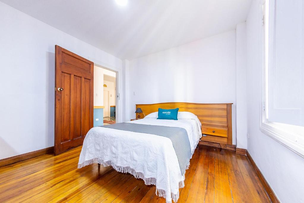 a bedroom with a bed with a blue pillow on it at Ayenda Nuevo Escorial in Manizales
