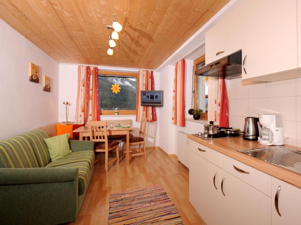cocina y sala de estar con sofá y mesa en Single Apartment Martlerhof, en Tux