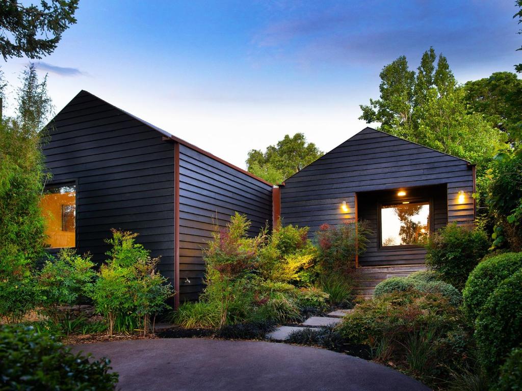 a black house with a garden in front of it at Hardwood House in Daylesford
