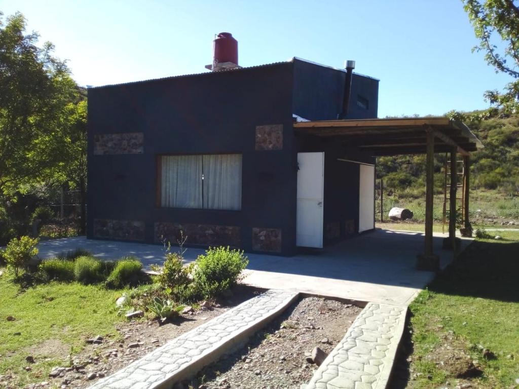 a black house with a white door and a garage at CASA CUBO in Tunuyán
