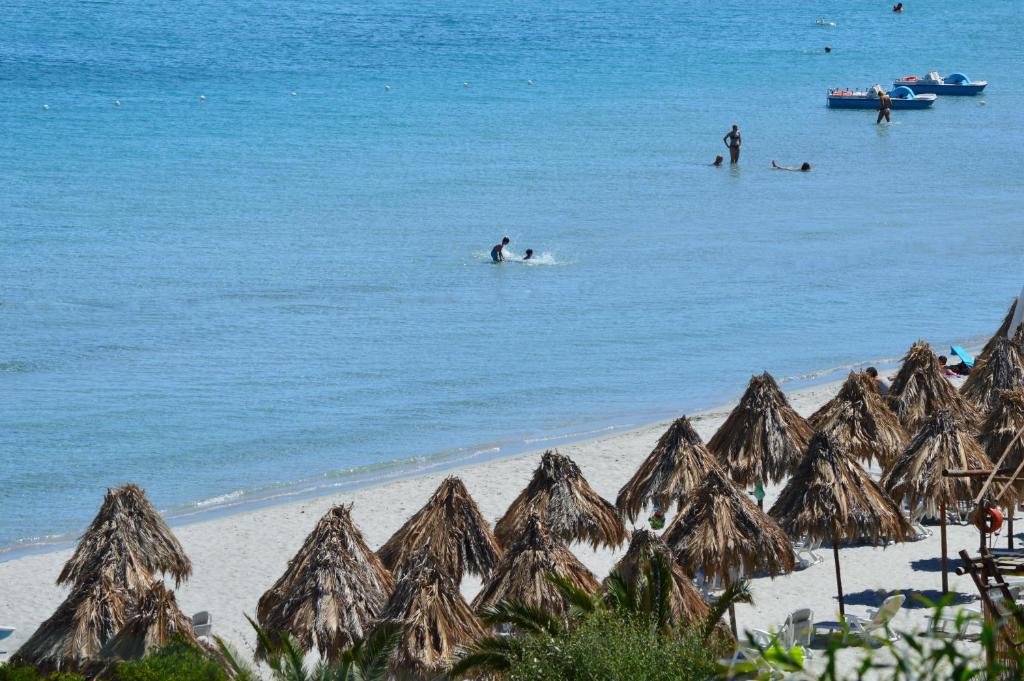 a group of people in the water on the beach at Residence Fenicia in Villasimius