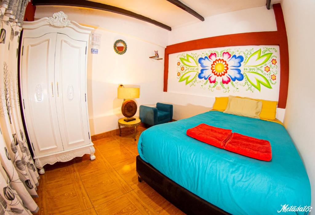 um quarto com uma cama com um quadro na parede em Bull House em Urubamba