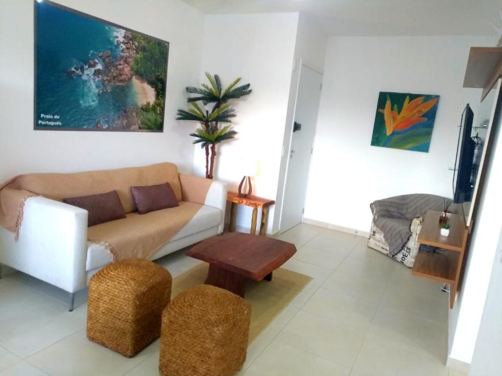 a living room with a couch and a table at APTo 300MTS DA PRAIA, VISTA PARA O MAR, CHURRASQUEIRA, WI-FI, AR CONDICIONADO, TOTALMENTE EQUIPADO in Ubatuba