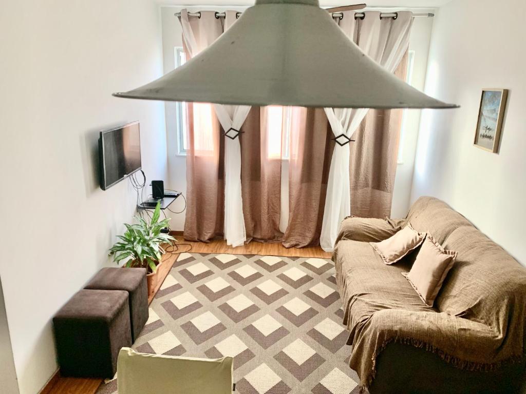 a living room with a couch and a large light fixture at Apto Praia Atalaia in Aracaju