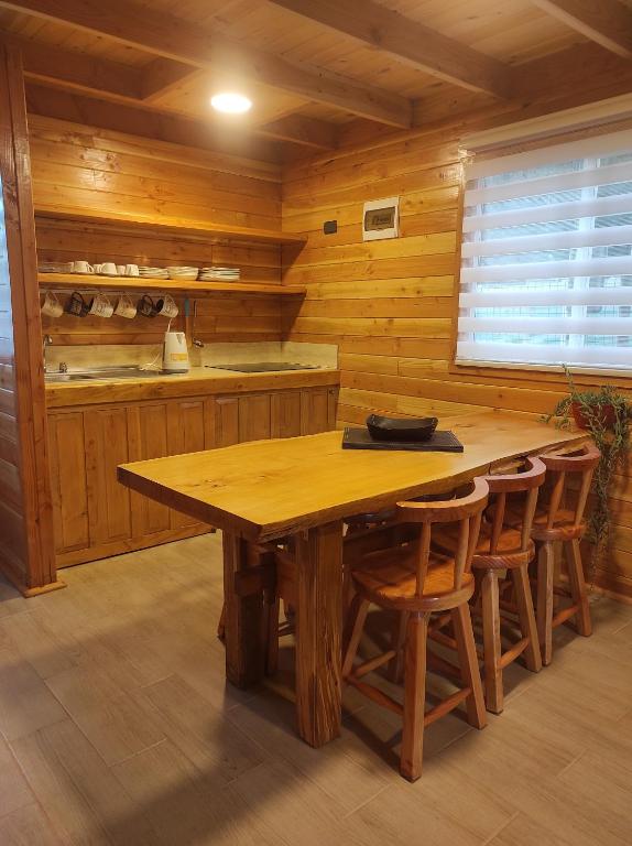 una cocina de madera con mesa y sillas de madera en Cabañas Los Arrayanes en Licán Ray