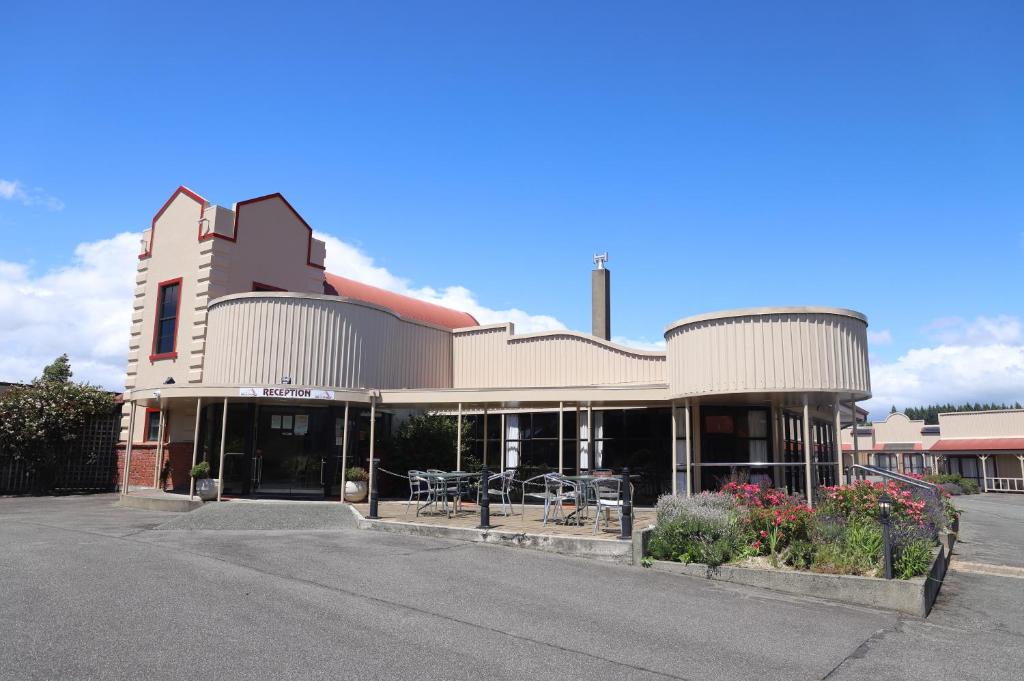 a large brick building with a view of a city at The Village Inn Hotel in Te Anau