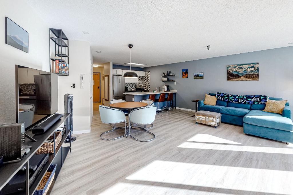 a living room with a blue couch and a table at Snowblaze Studio in Winter Park