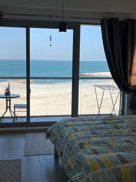 um quarto com uma cama e vista para a praia em Incredible Ocean View Studio Aprtment in Al Marjan Island em Ras al-Khaimah