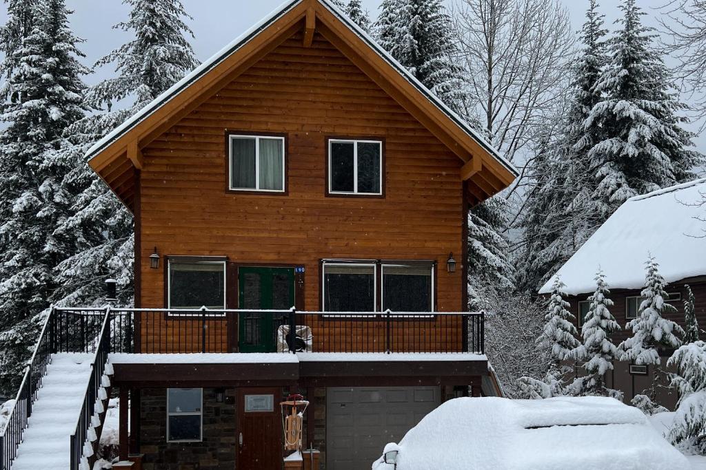 domek z bali i śniegiem na ganku w obiekcie Alpine Trails Lodge w mieście Snoqualmie Pass