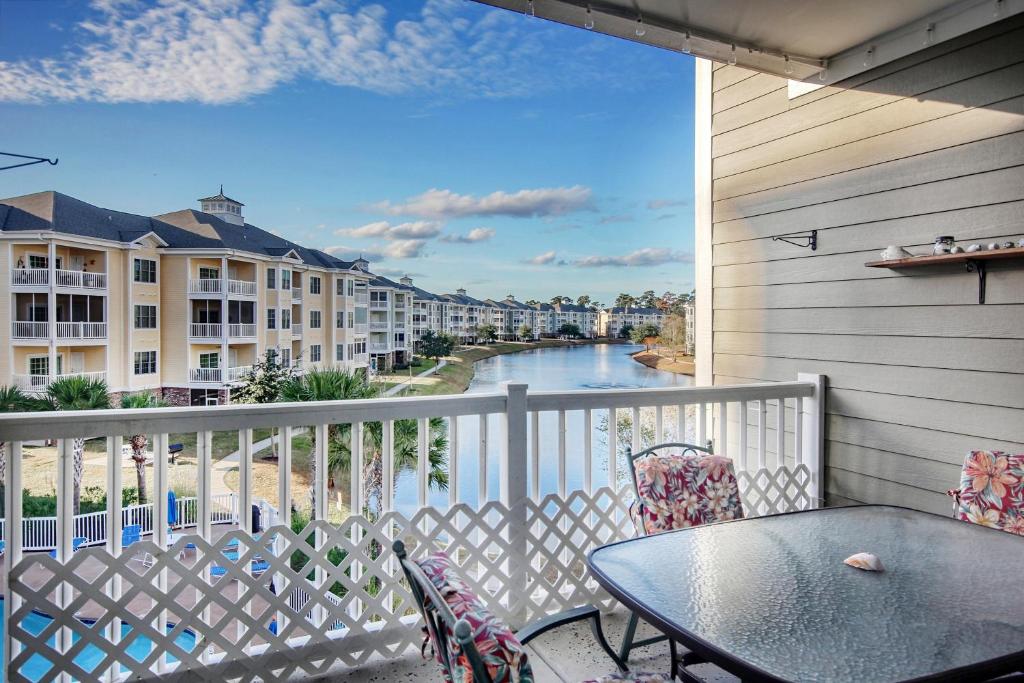 a balcony with a table and chairs and a view of a river at Myrtle Magic in Myrtle Beach