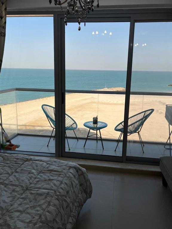 een slaapkamer met een bed en uitzicht op het strand bij BEAUTIFUL STUDIO APARTMENT IN AL MARJAN ISLAND in Ras al Khaimah