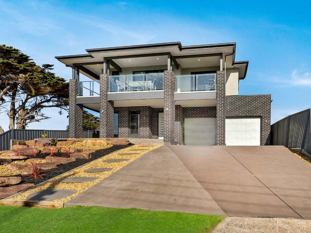 a house with a walkway in front of it at Castaway Views in San Remo