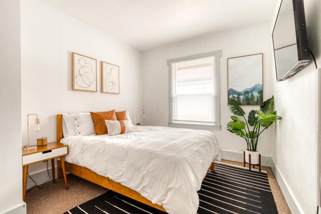 a white bedroom with a bed and a desk at Cascade Cabana & Home in Hood River