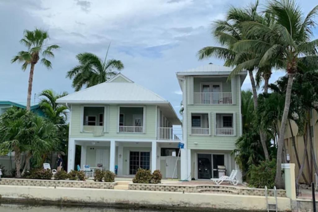 uma casa sobre a água com palmeiras em Skyway Living em Summerland Key