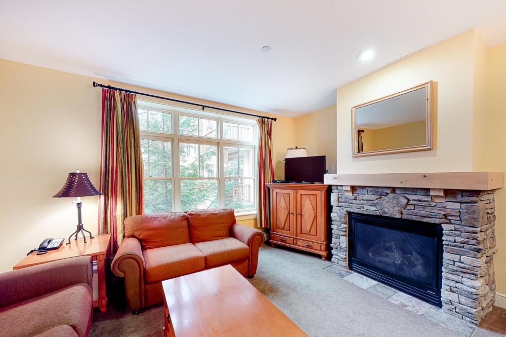 a living room with a fireplace and a tv at Founders Lodge 209 in Stratton