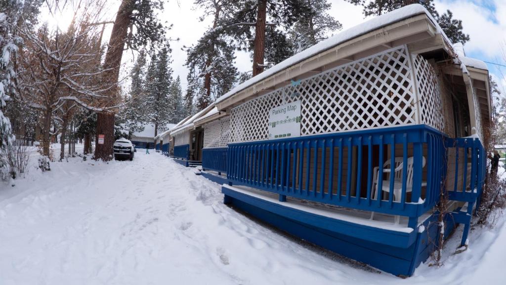 una jaula de pájaro azul sentada en la nieve en Cathy's Cottages en Big Bear Lake