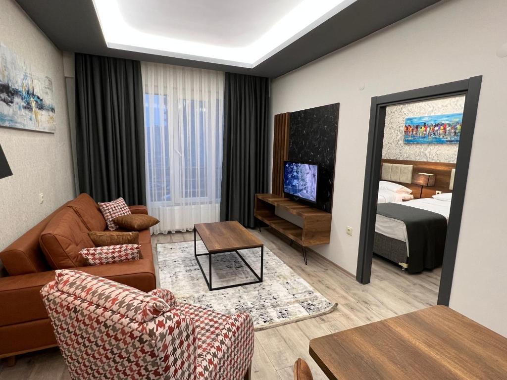 une chambre d'hôtel avec un lit et un salon dans l'établissement PRIME INN CITY, à Melikgazi