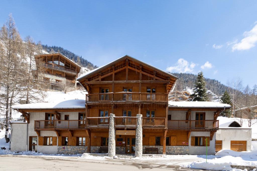 um grande edifício de madeira com neve no chão em Chalet Coeur des Brévières by Chalet Chardons em Tignes