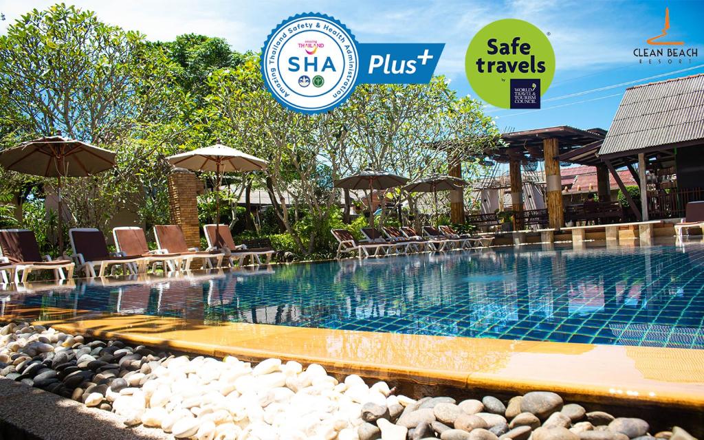 a swimming pool with chairs and umbrellas at a hotel at Clean Beach Resort in Ko Lanta